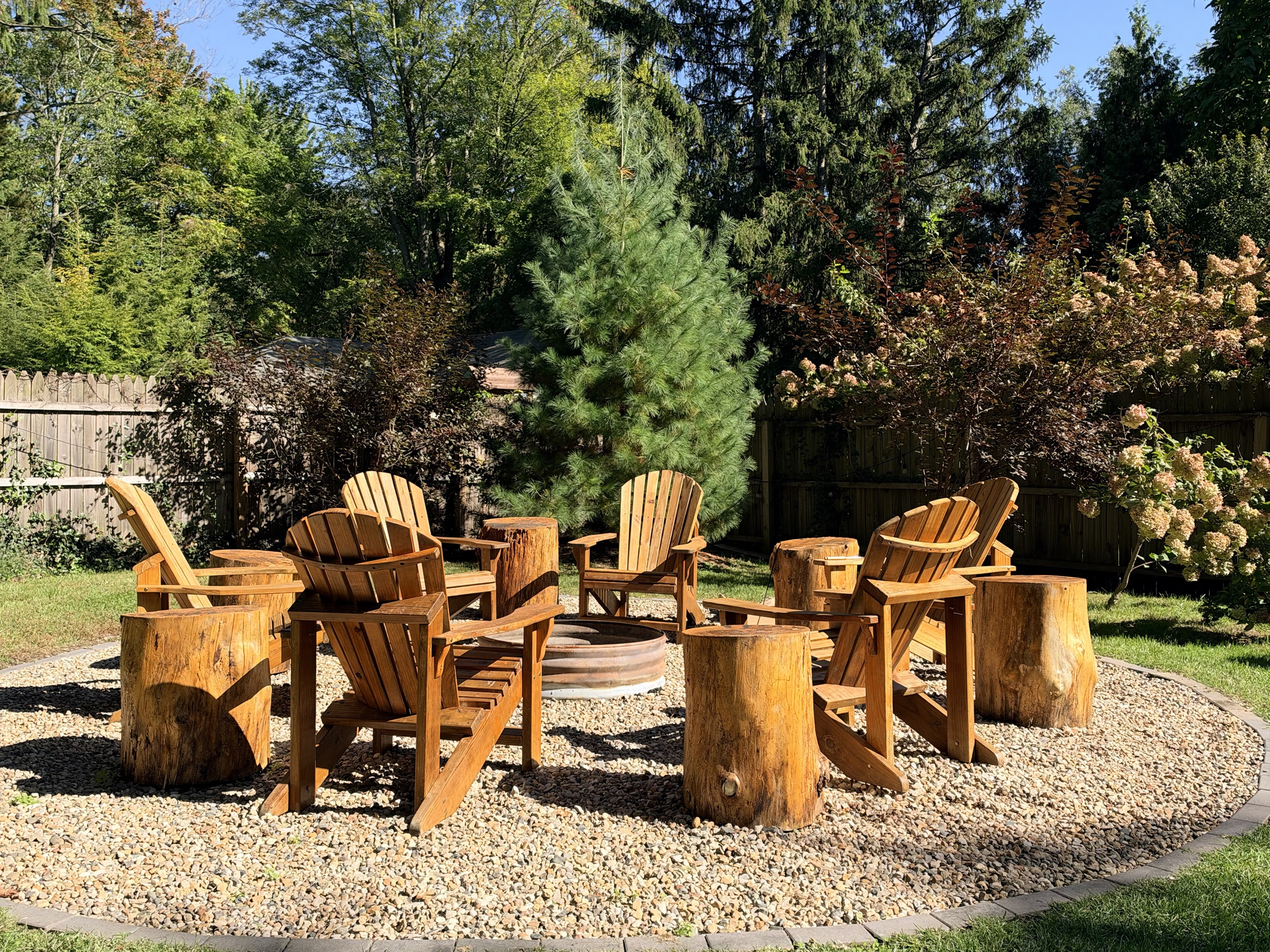 Fire pit circle with Adirondack chairs and stump side tables