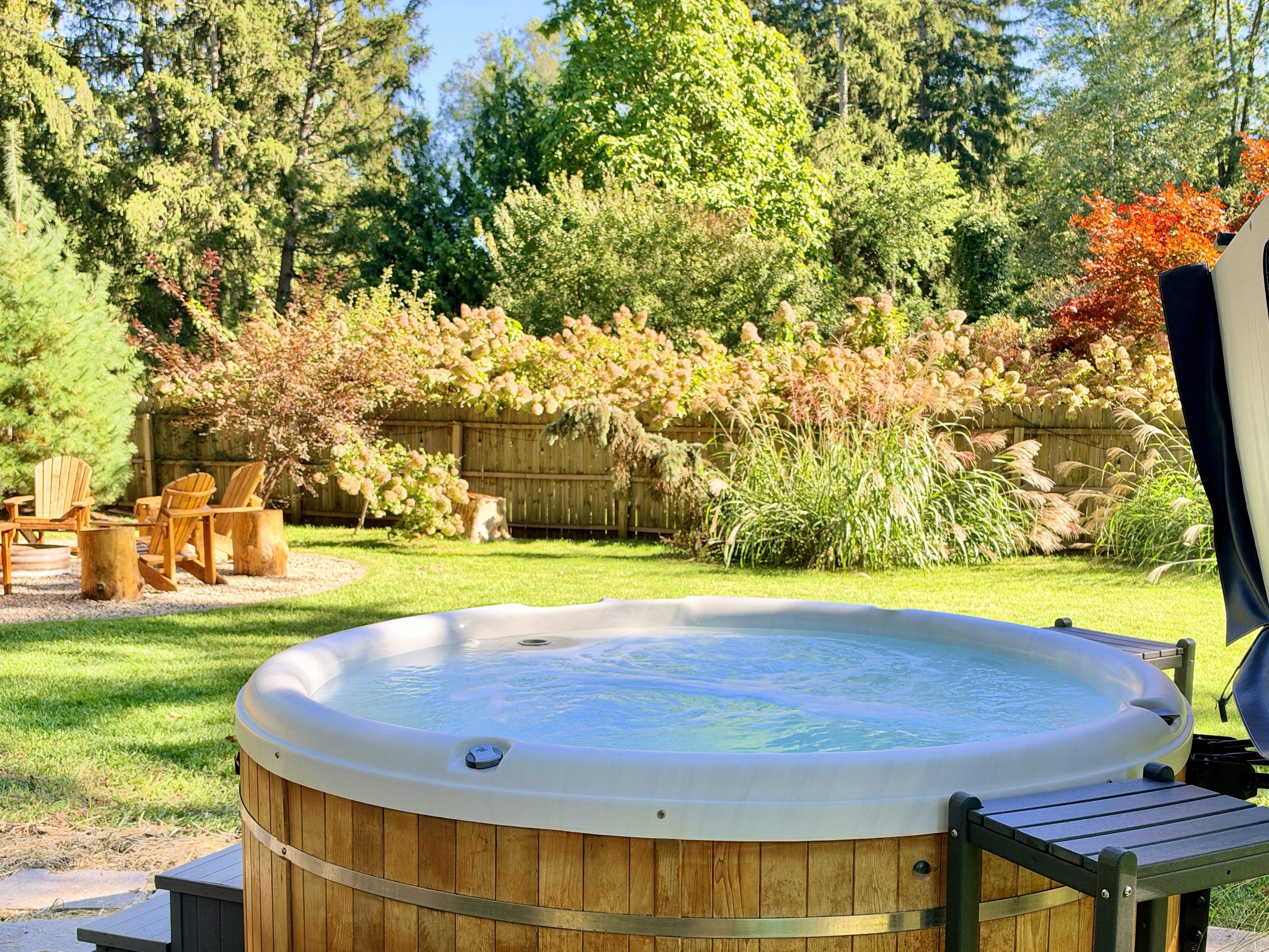 Cedar hot tub with fall foliage and fire pit in the backyard