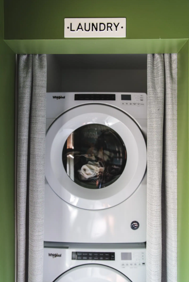 In-unit stacked washer and dryer in green laundry nook